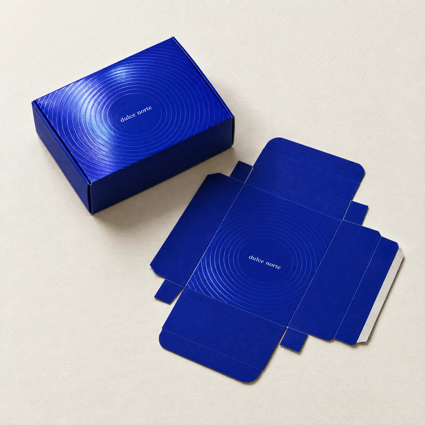 Caja plegadiza azul con barniz UV de círculos, armada y desplegada